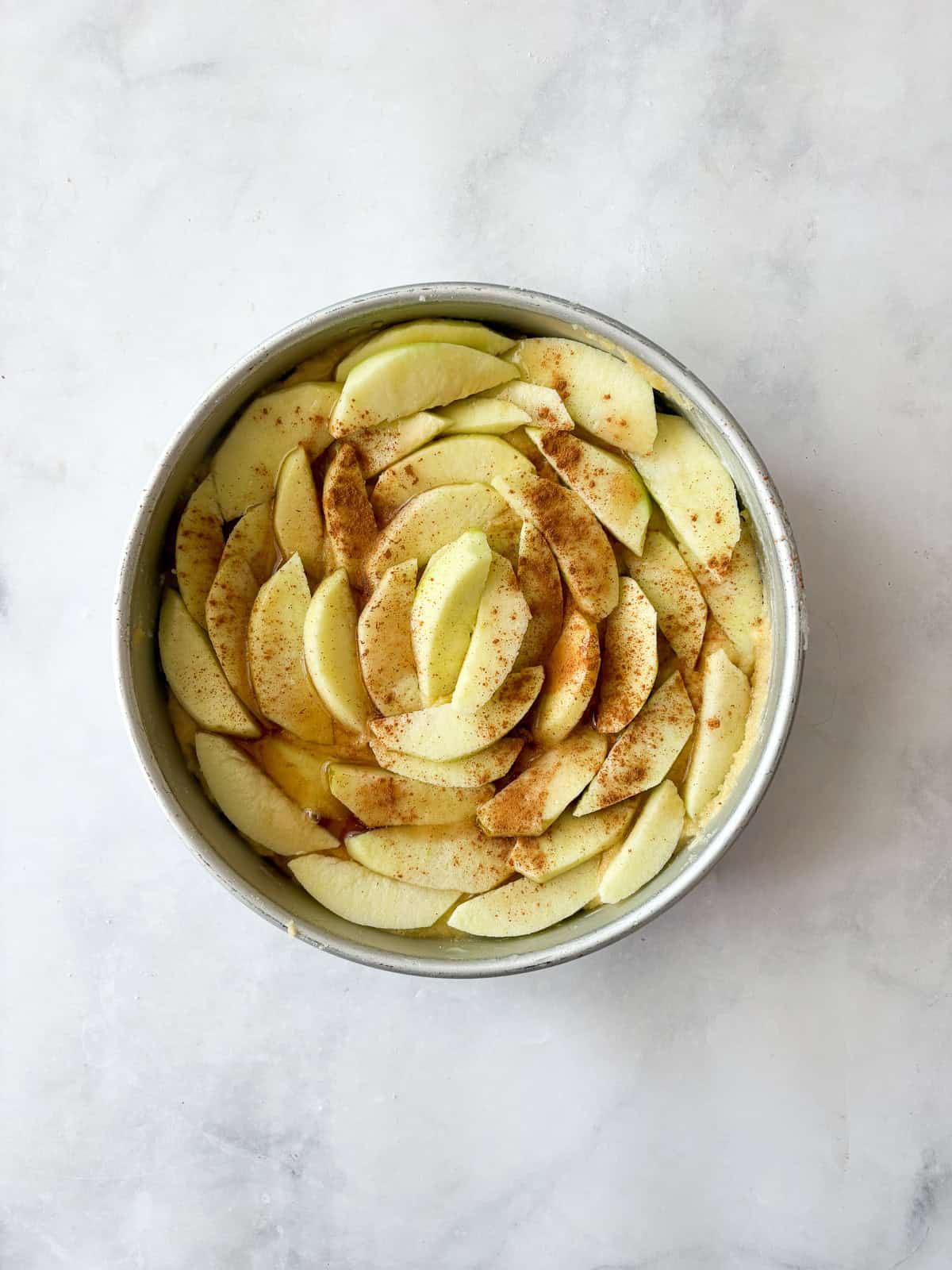 This rich-tasting almond flour apple cake has a wonderfully moist and tender crumb that's topped with sliced apples and maple syrup. Apple slices are added to the top of cake batter for almond flour apple cake.