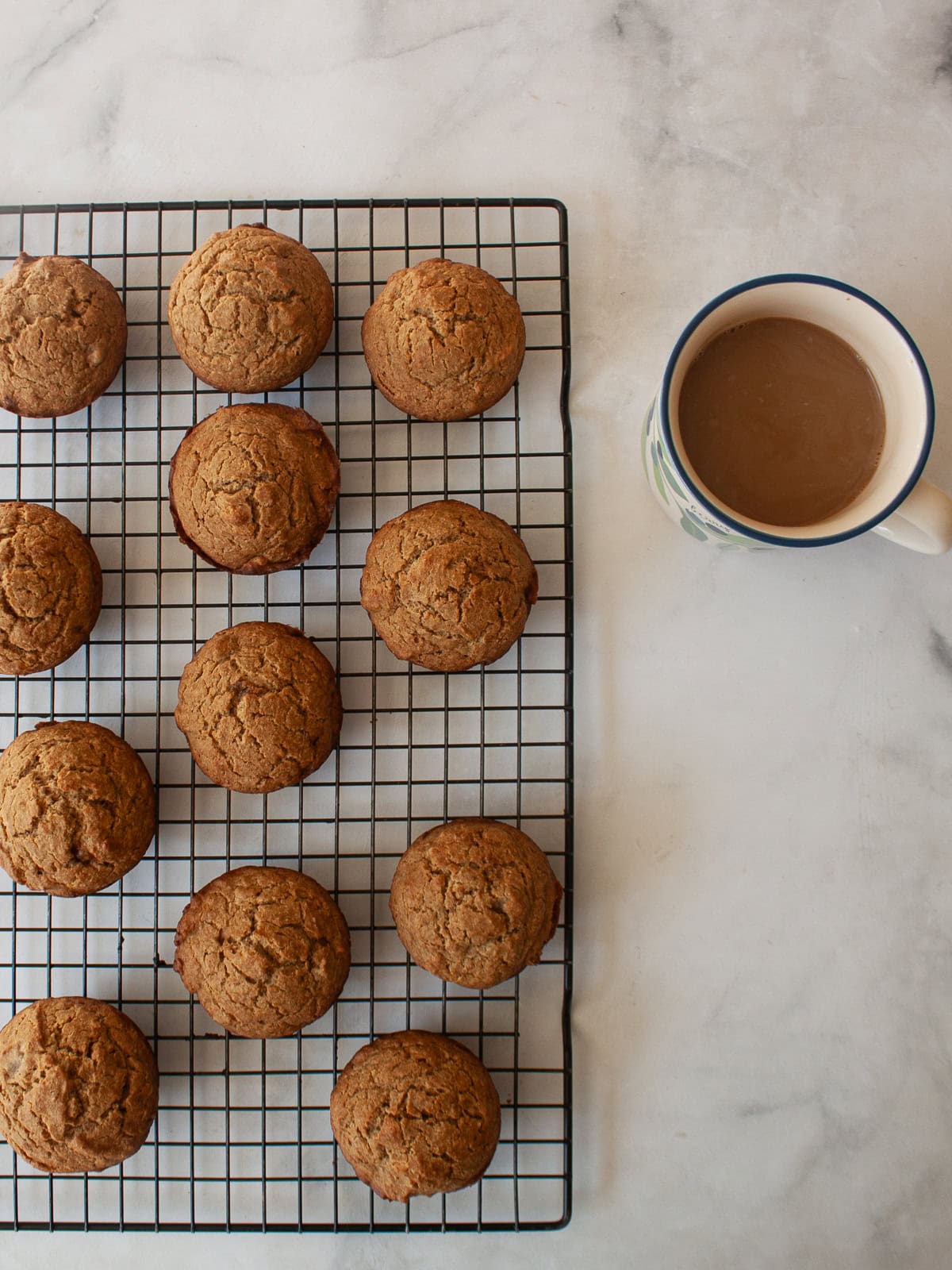 Simple and wholesome, these whole grain applesauce muffins are packed with unsweetened applesauce. Easy to make gluten-free, dairy-free, etc. Applesauce muffins on a wire rack next to a cp of coffee.