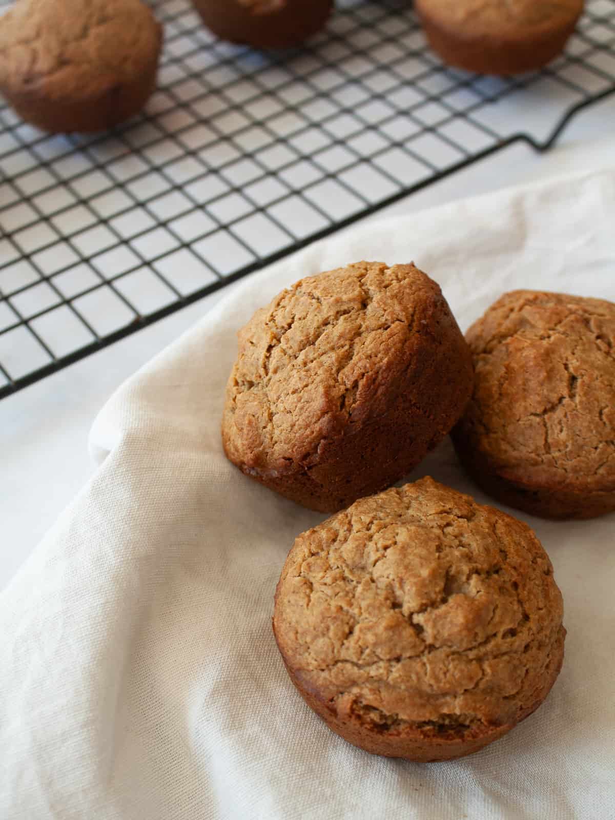 Simple and wholesome, these whole grain applesauce muffins are packed with unsweetened applesauce. Easy to make gluten-free, dairy-free, etc. Applesauce muffins on a napkin.