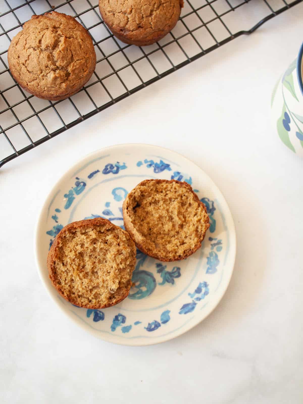 Simple and wholesome, these whole grain applesauce muffins are packed with unsweetened applesauce. Easy to make gluten-free, dairy-free, etc. An applesauce muffin split in half on a plate.