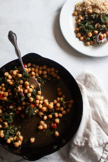 A cast iron skillet of beans and greens and a plate of beans and greens.