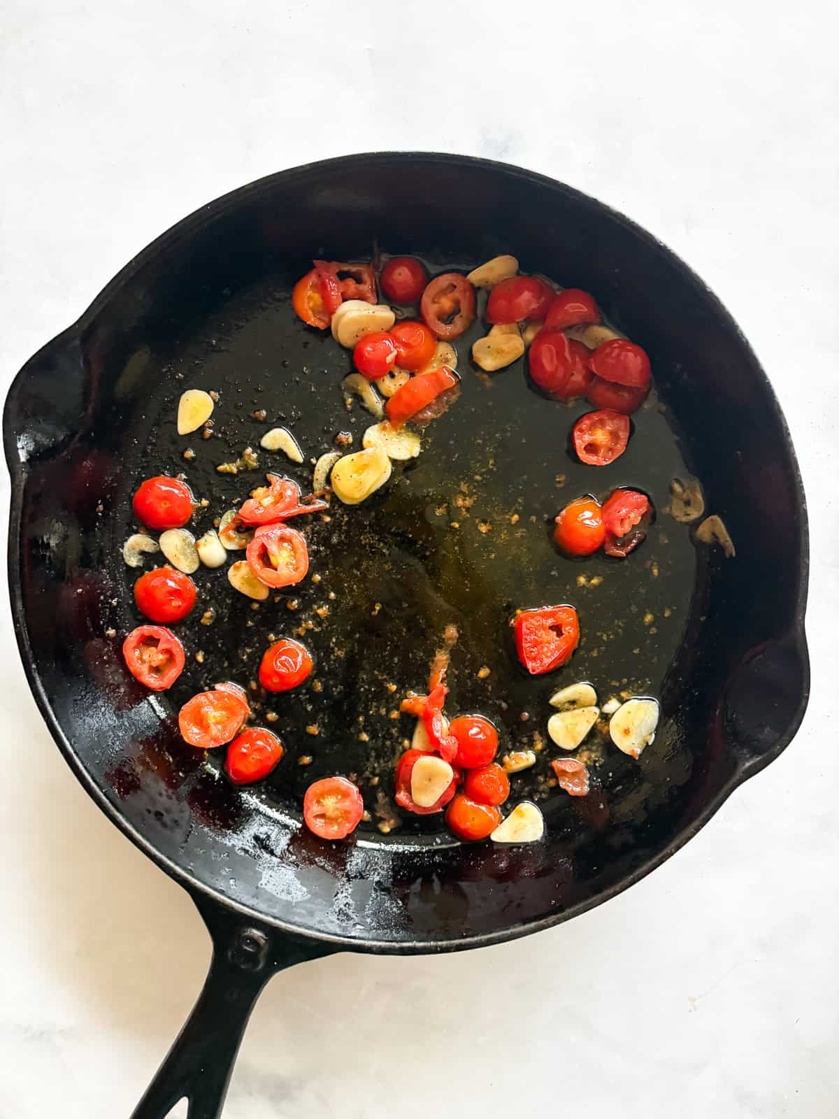 This easy beans and greens recipe comes together in minutes with pantry beans and fresh greens. A simple, adaptable weeknight meal. Garlic and tomatoes cook in a skillet for beans and greens.