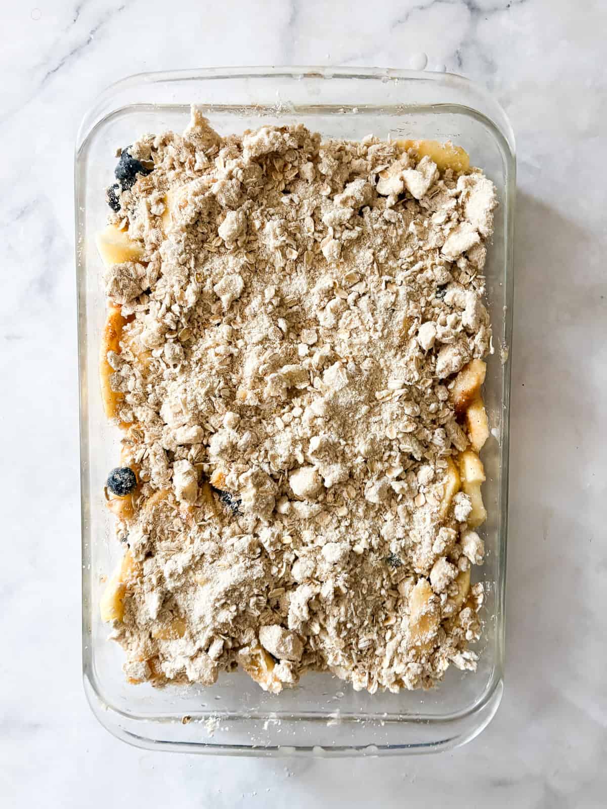 This apple blueberry crisp combines juicy summer apples and berries under a buttery oat topping. A seasonal dessert that's delicious warm. Topping is added to fruit for apple blueberry crisp.
