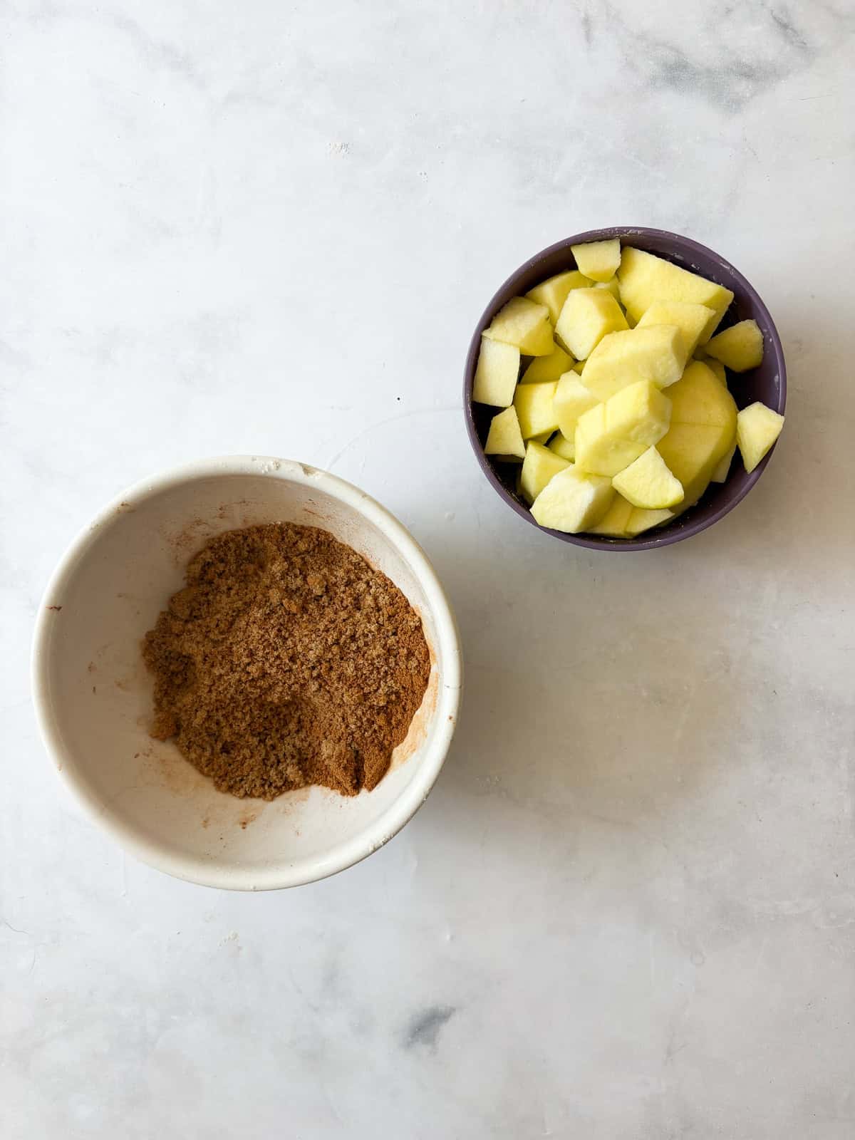 This gluten free apple bread is soft, buttery, and generously layered with fresh apples, cinnamon, and brown sugar. A one-bowl recipe! Cinnamon and brown sugar in a bowl, and chopped apples.