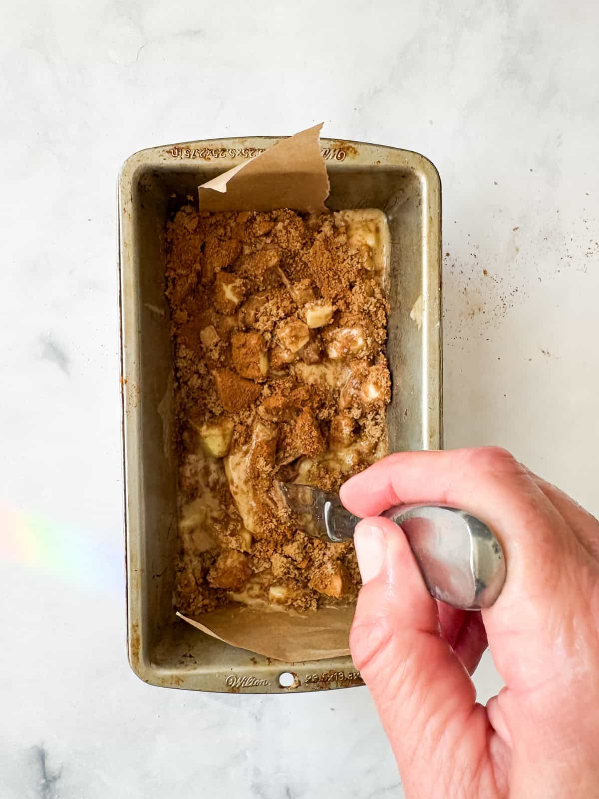 This easy apple walnut bread is tender and filled with fresh apples and crunchy walnuts. Make it with whole wheat flour or oat flour. Using a knife to swirl the cinnamon sugar into the batter.