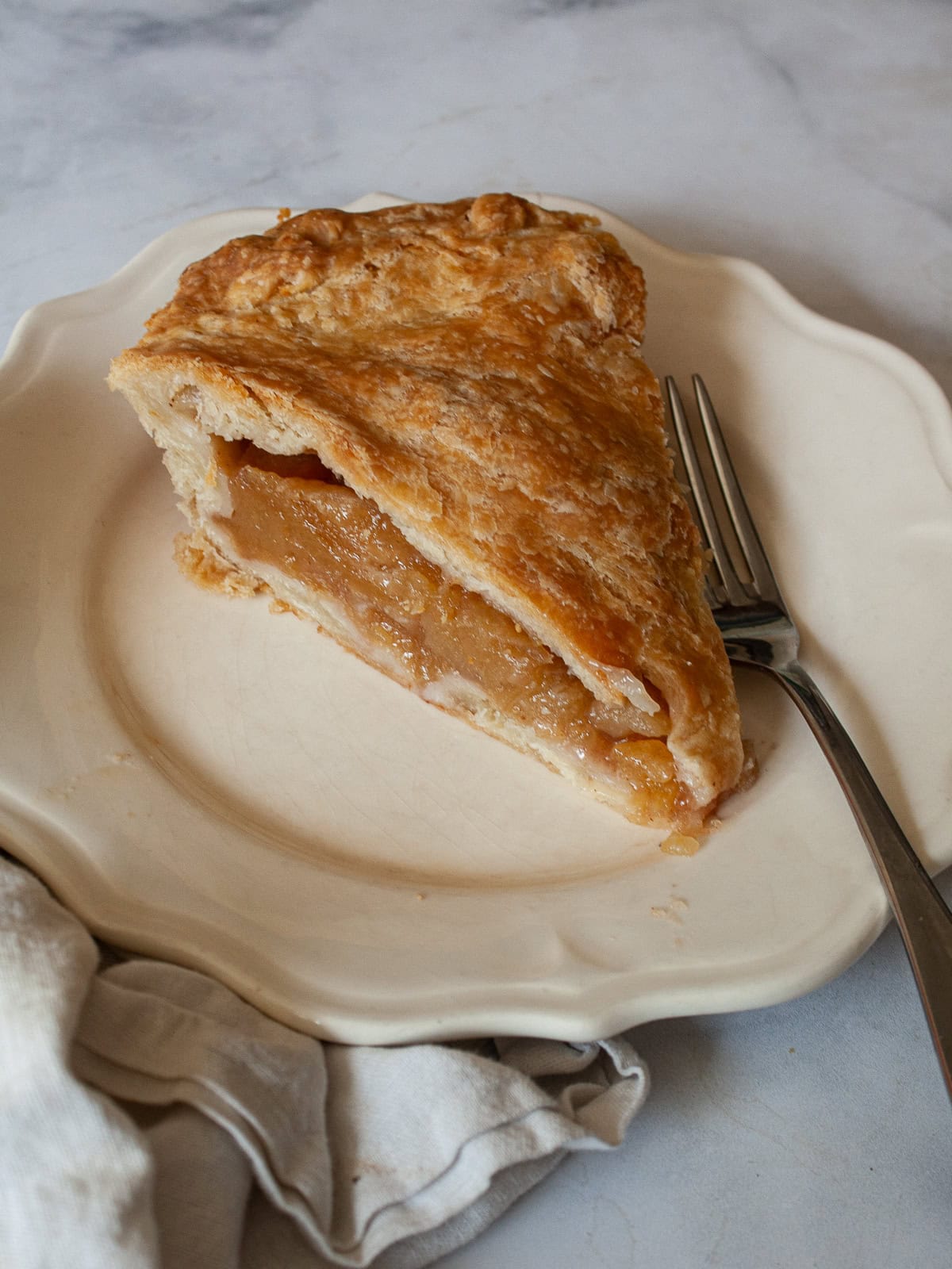 Fold tart-sweet apples into a flaky gluten free crust in this luscious gluten free Gravenstein apple pie recipe. A slice of gluten free Gravenstein apple pie on a plate.