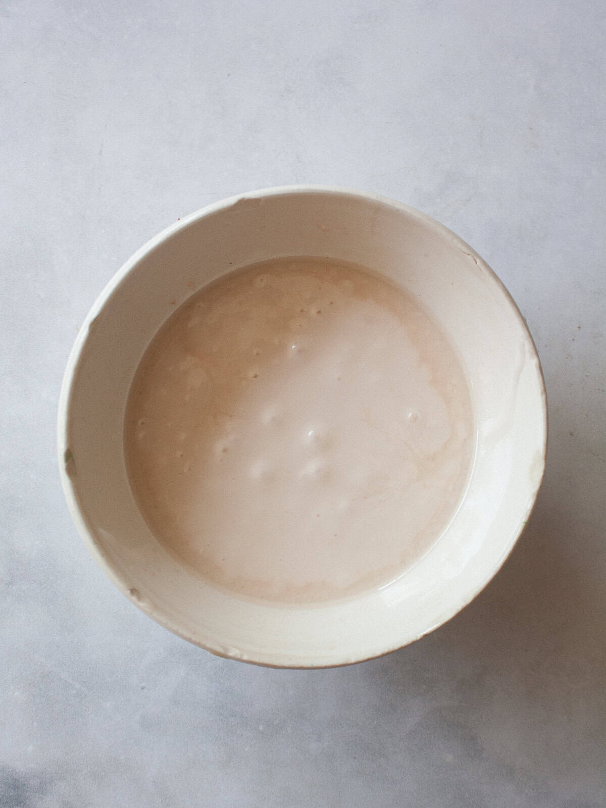A sweet, lightly pink grapefruit glaze that is so lovely on loaf cakes, regular cakes, cookies, and anywhere else you need a flavor boost! A bowl of grapefruit glaze.