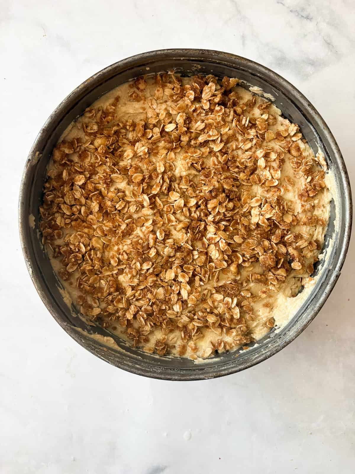 This delicious apple crumb cake is layered with apples, cinnamon, oats, and walnuts. Make it with whole wheat or oat flour for a GF version. Oat topping is scattered across the top of an apple crumb cake.