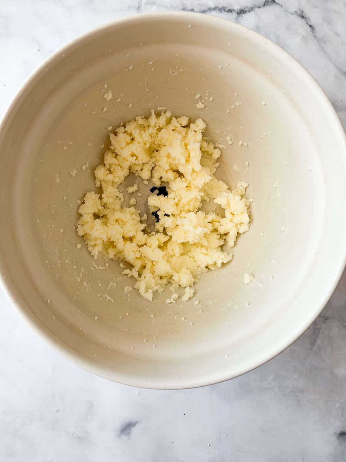 Butter is creamed with sugar for apple crumb cake.