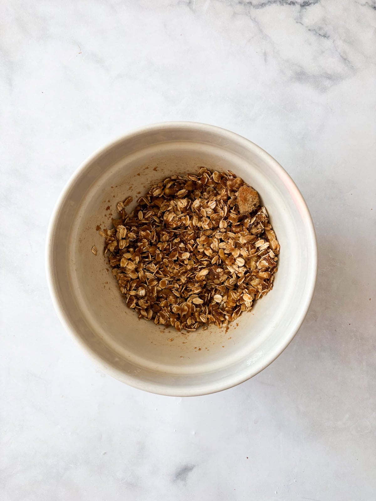 This delicious apple crumb cake is layered with apples, cinnamon, oats, and walnuts. Make it with whole wheat or oat flour for a GF version. Oat topping/filling for apple crumb cake in a bowl.