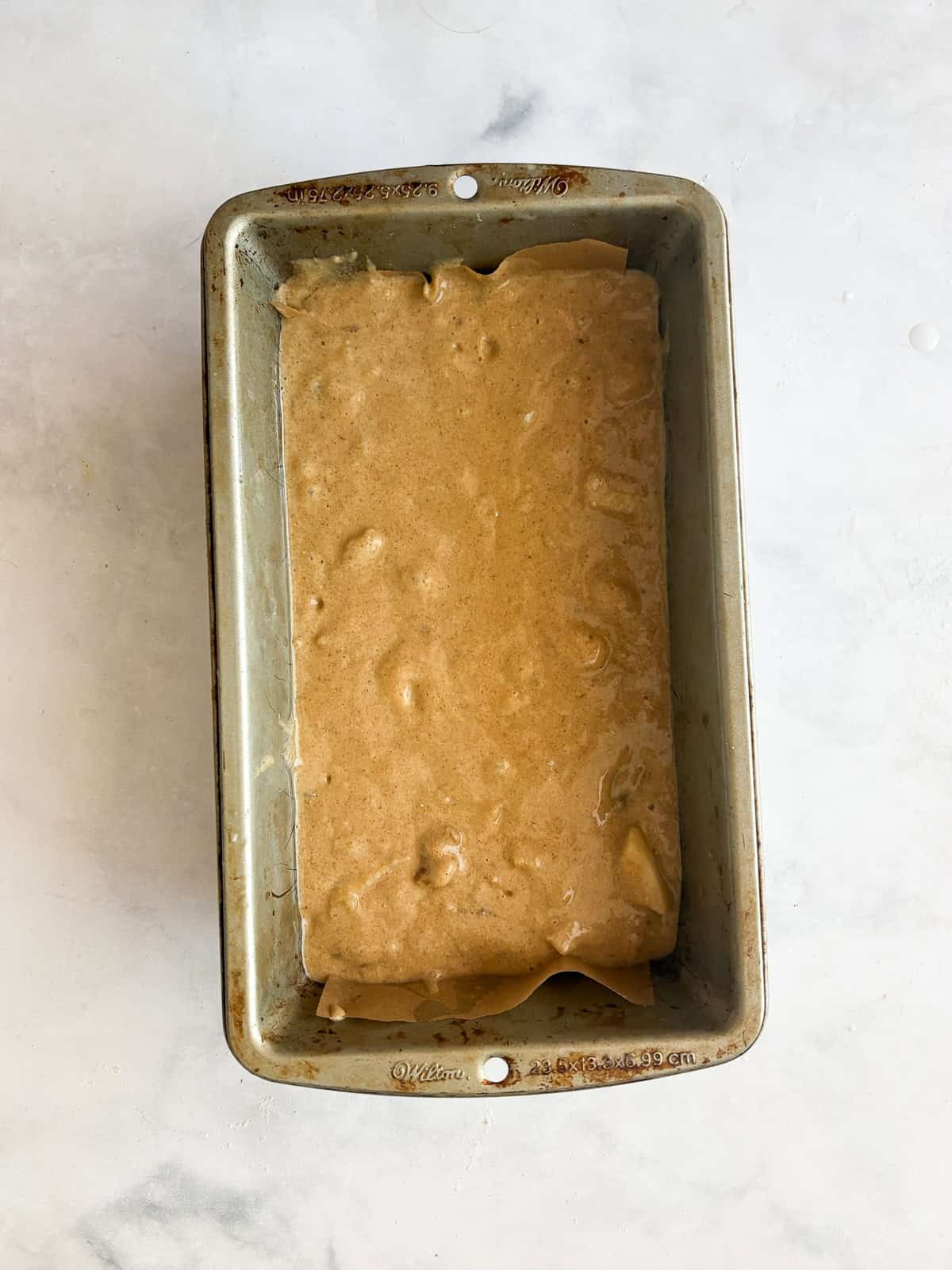 Easy banana pear bread made with whole wheat or gluten-free oat flour, juicy pears, and walnuts. A tender quick bread for fall and beyond. Pears are added to banana pear bread batter and placed in a loaf pan.