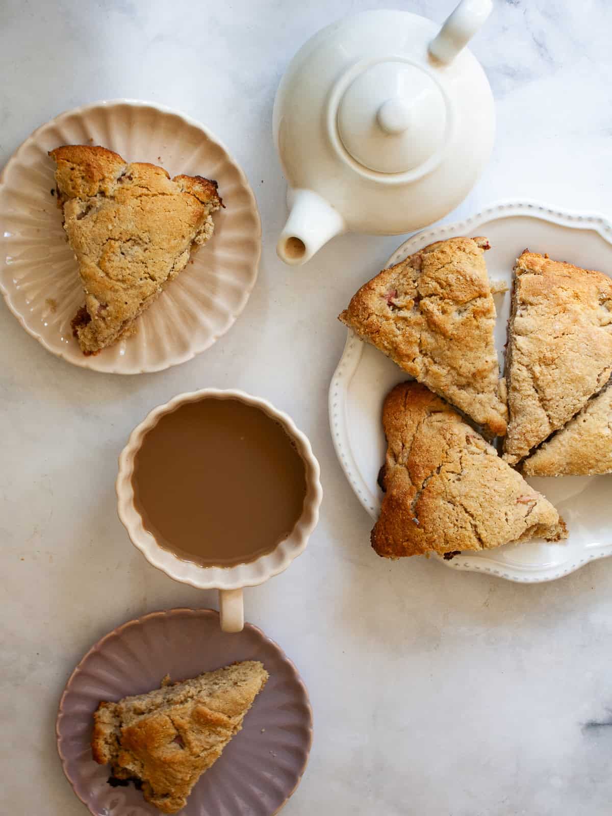 The simplest, tenderest gluten free oat flour scones that are made just with oat flour. Use this recipe as your base for all sorts of add-ins, from fruit, to chocolate, to maple syrup. A tea pot and a cup of tea and oat flour scones.