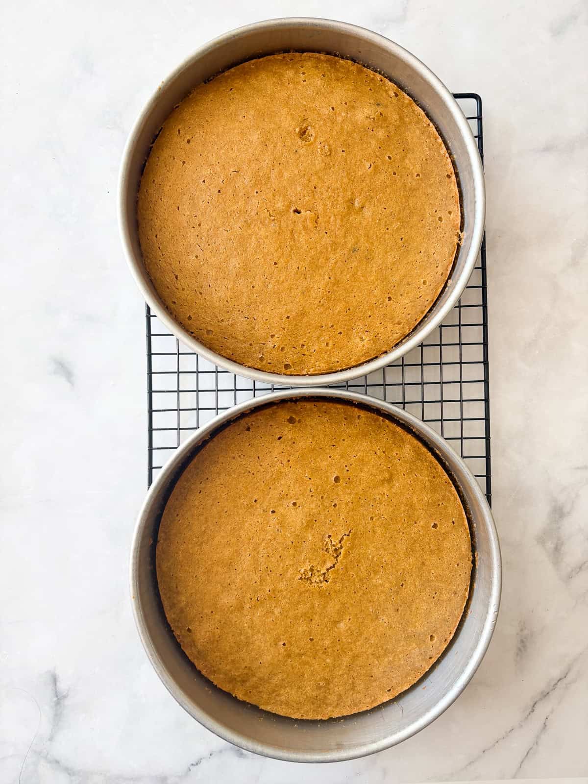 This beautiful gluten free pumpkin layer cake is rich and moist, warmly spiced, and frosted with a plush, sweet-tangy cream cheese frosting. A gluten free pumpkin layer cools in pans on a rack.