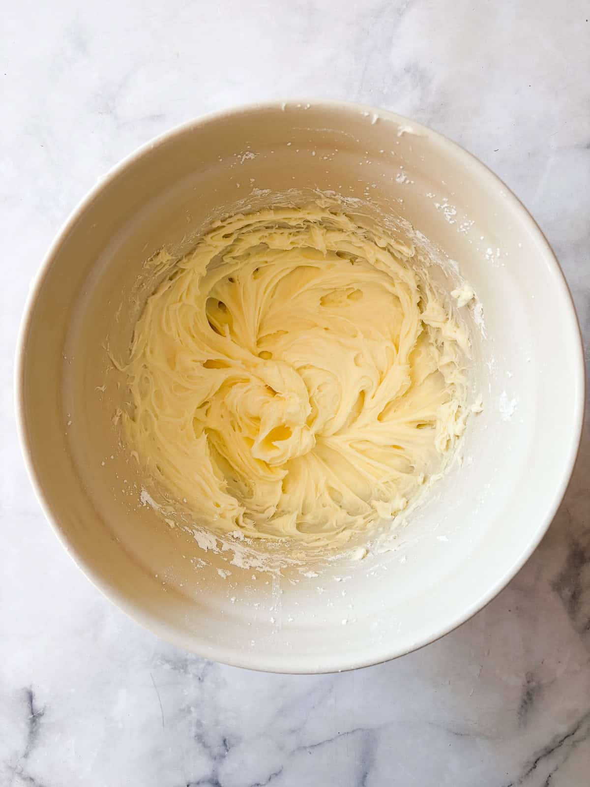 This beautiful gluten free pumpkin layer cake is rich and moist, warmly spiced, and frosted with a plush, sweet-tangy cream cheese frosting. Cream cheese frosting whipped together in a bowl.