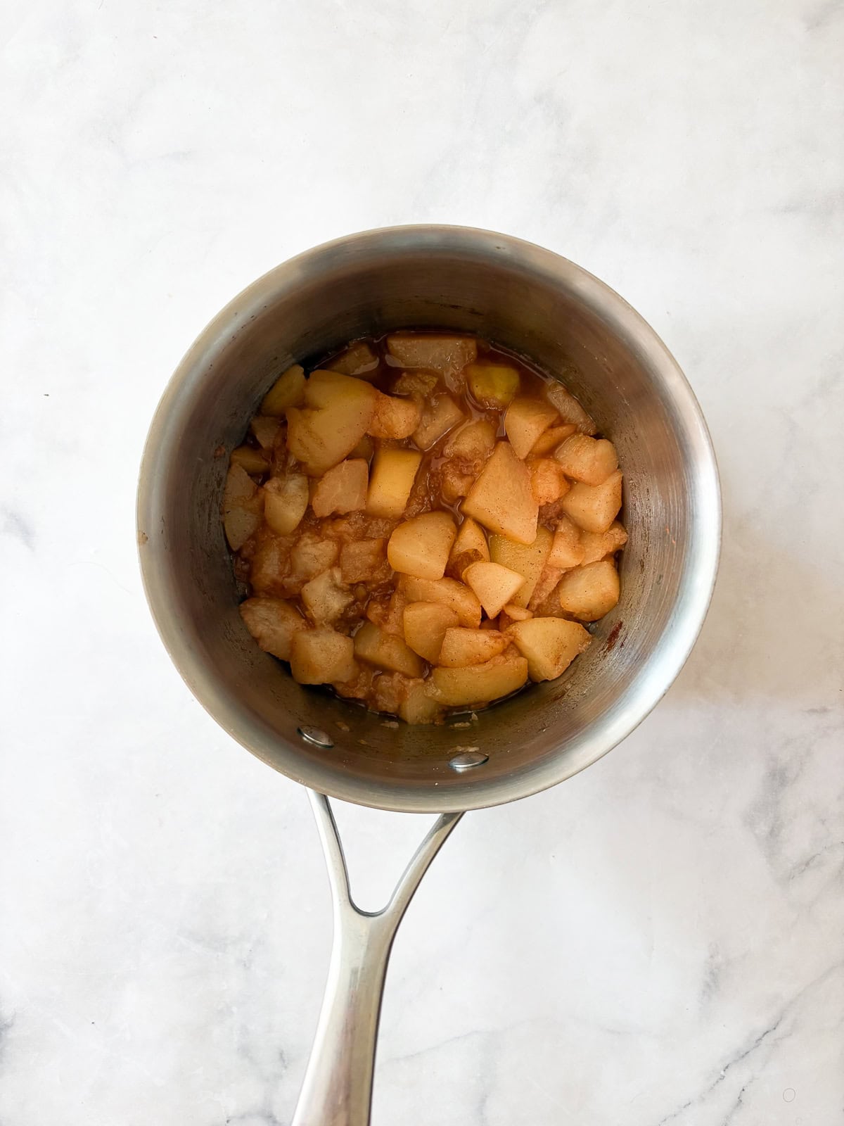 A smooth, sweet pear sauce that's best made with ripe pears! Add cinnamon and maple syrup if you like, or enjoy it plain. Pears cooking down for pear sauce in a pot.