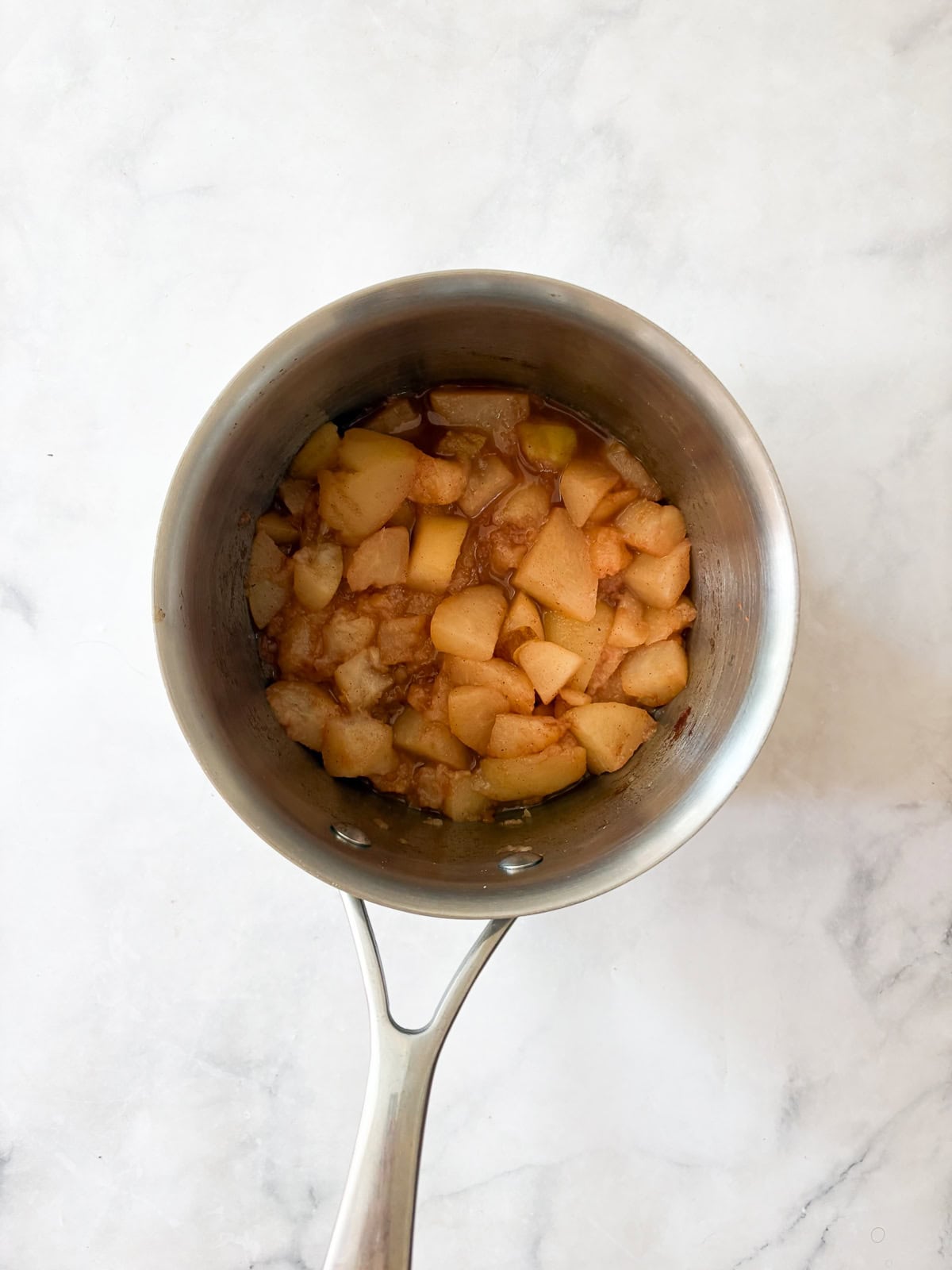 A smooth, sweet pear sauce that's best made with ripe pears! Add cinnamon and maple syrup if you like, or enjoy it plain. Pears cooking down in a pot for pear sauce.